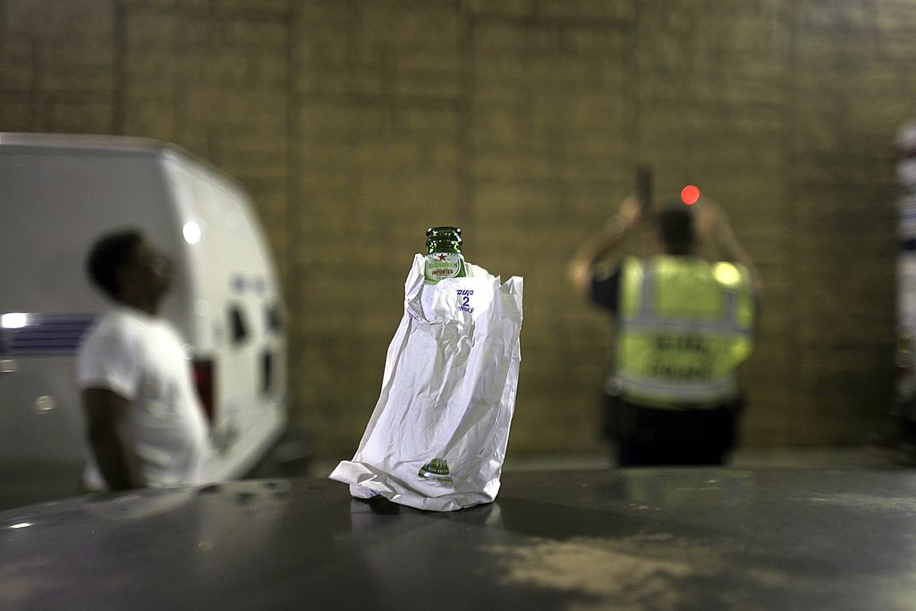 Beer bottle in paper bag with DUI stop in background - DUI Attorney in Ogden, UT