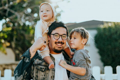 Smiling Father holding his kids - Immigration Lawer at Richards & Richards Law Firm