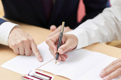 Person in Ogden, UT signing documents with a lawyer guiding them for probate law services