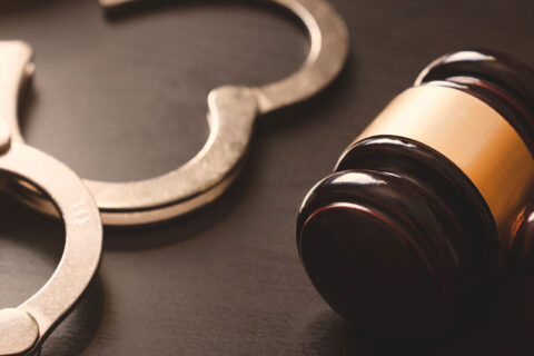 Gavel and handcuffs on a table symbolize criminal defense attorney services in Ogden, UT