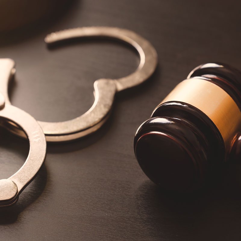 Gavel and handcuffs on a table symbolize criminal defense attorney services in Los Angeles, CA