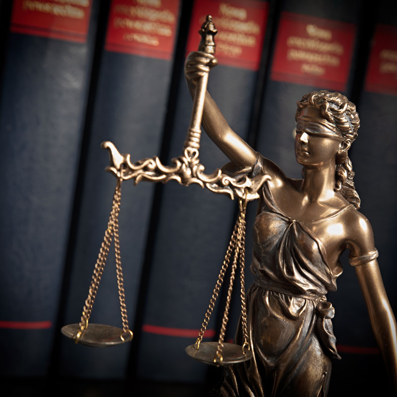 Scales of Justice Statue near law books in an Los Angeles, CA office