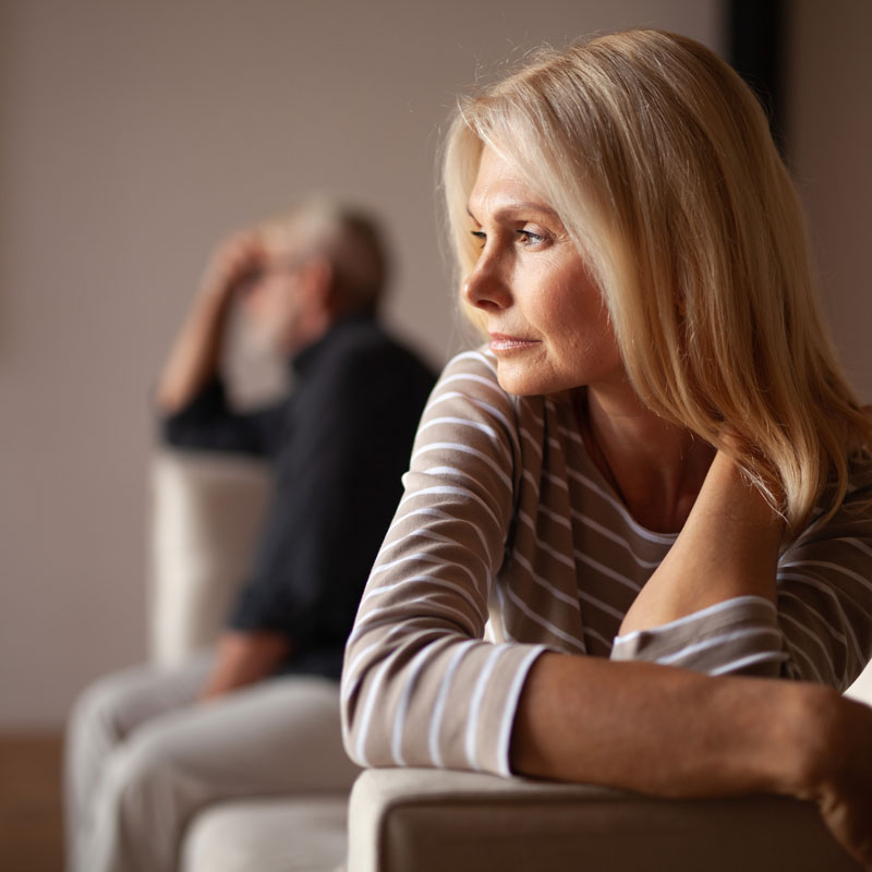 Upset couple sitting apart on sofas, hinting at a fight, represented by experienced annulment lawyers in Ogden, UT