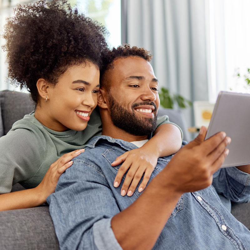 Couple in Ogden, UT sitting on couch, looking at a laptop for family law help