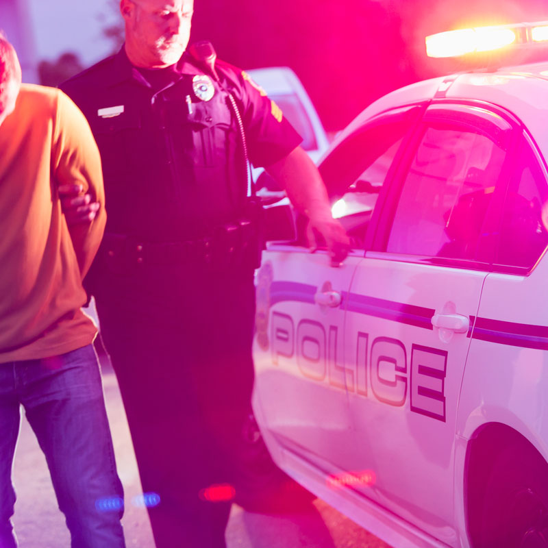 Police officer in Ogden, UT putting handcuffs on a man for a DUI arrest