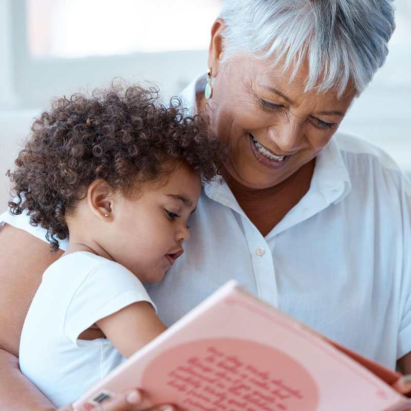 Grandmother in Ogden, UT, sharing a story from a book with her young granddaughter