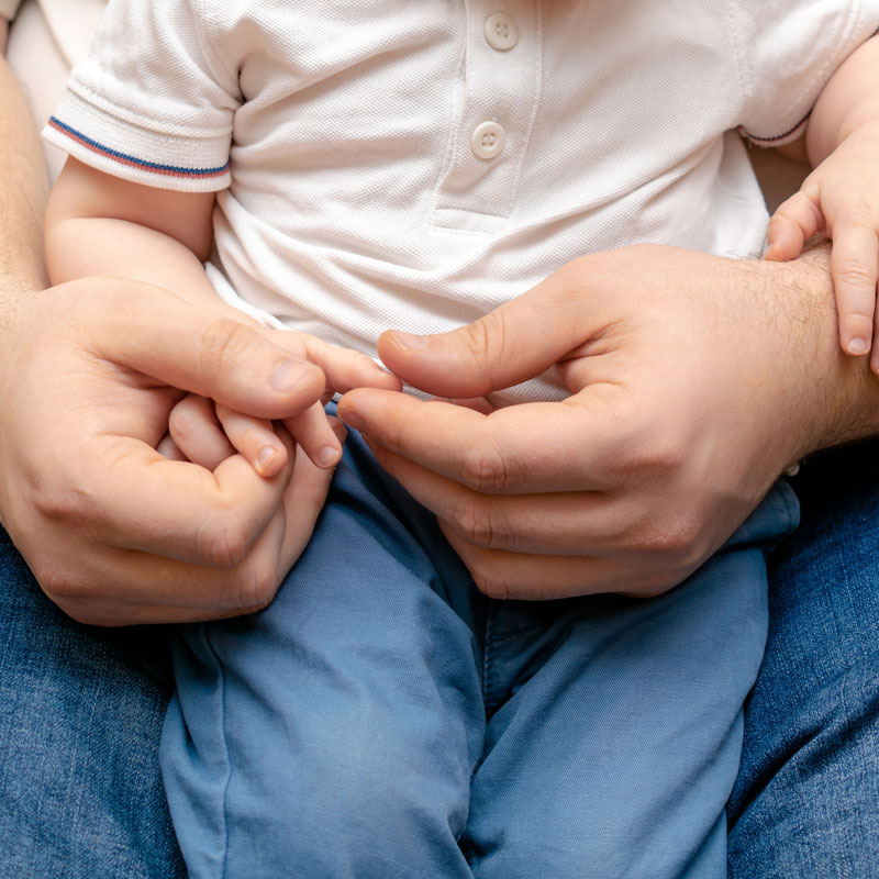 Father from Ogden, UT lovingly holding his child, seeking paternity rights