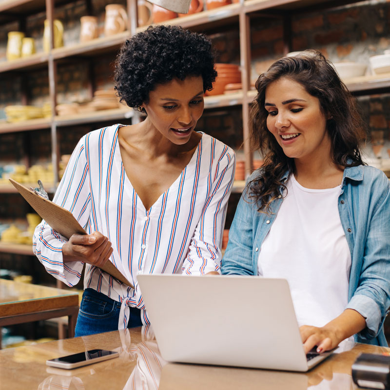 Two girls in Los Angeles, CA discussing small business opportunities on a laptop