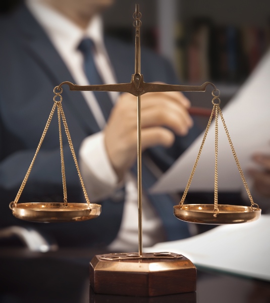 Scales of justice with lawyer in background - Richards & Richards Law Firm in Utah