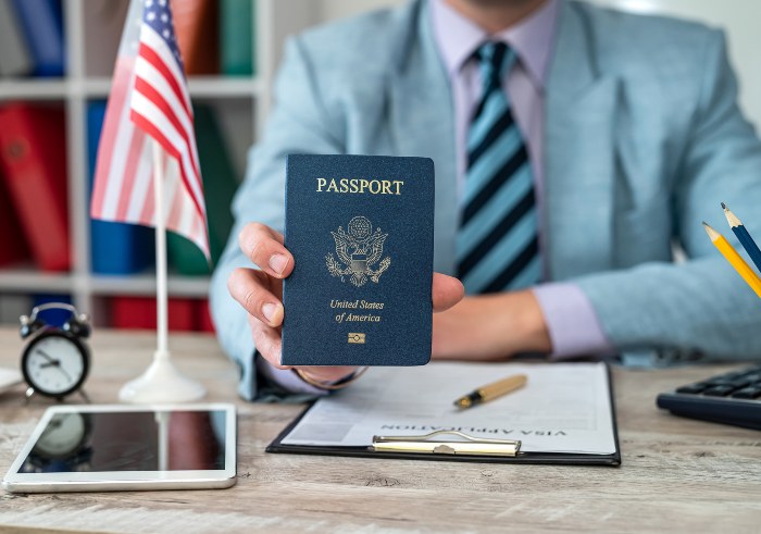 Immigration Lawyer working on visa application documents and holding USA Passport